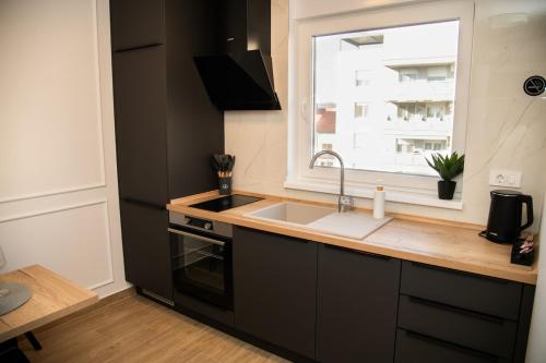 a kitchen with a sink and a window at New apartment May in the city center, parking free in Slavonski Brod