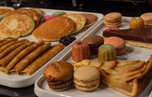 a tray of different types of pastries and muffins at Idol Hotel in Paris