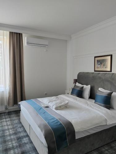 a bedroom with a large bed with blue pillows at Hotel Mio City in Kula