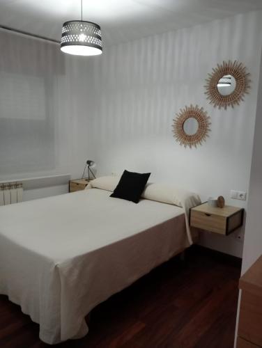 ein Schlafzimmer mit einem großen weißen Bett und einem Spiegel in der Unterkunft A Marea in Moaña