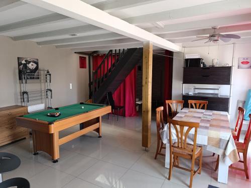 a living room with a pool table and a dining room at Maison de bourg entre Nantes et Cholet in Saint-Crespin-sur-Moine