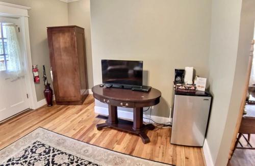 a room with a table with a laptop on top of it at Brownstone Spring Suite - Double Spa Tub Parking in Eureka Springs