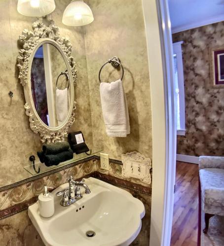 a bathroom with a sink and a mirror at Brownstone Spring Suite - Double Spa Tub Parking in Eureka Springs