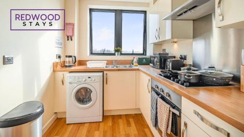 a kitchen with a washing machine and a sink at Premium Serviced Apartment in Basingstoke Town Centre, Free Parking By Redwood Stays in Basingstoke