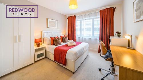 Cette chambre comprend un lit avec un bureau. dans l'établissement Premium Serviced Apartment in Basingstoke Town Centre, Free Parking By Redwood Stays, à Basingstoke