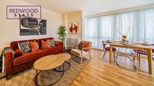 un salon avec un canapé rouge et une table dans l'établissement Premium Serviced Apartment in Basingstoke Town Centre, Free Parking By Redwood Stays, à Basingstoke