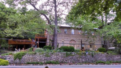 a large brick house with a stone wall at Brownstone Garden Suite Flat walk to Downtown in Eureka Springs