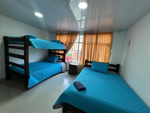 a bedroom with two bunk beds and a window at Hotel Casa Blanca Mirador in Güicán
