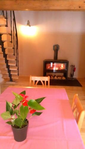 a table with a pink table cloth and a fireplace at House sid forest in Otočac