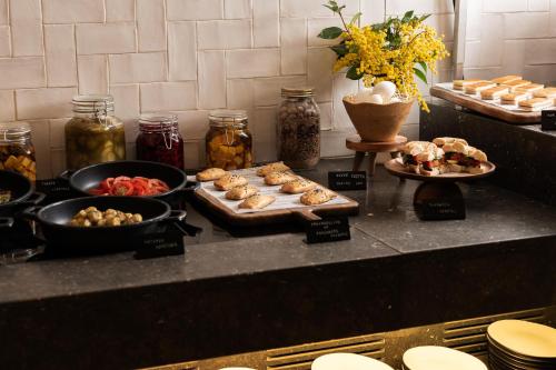 a buffet with different types of food on a counter at Hotel Pulitzer Barcelona in Barcelona
