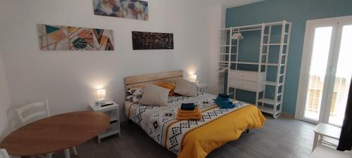a small bedroom with a bed and a table at Al Duca San Pietro in Carloforte