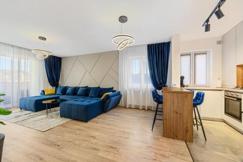 a living room with a blue couch and a kitchen at Blue Moon Apartments in Braşov