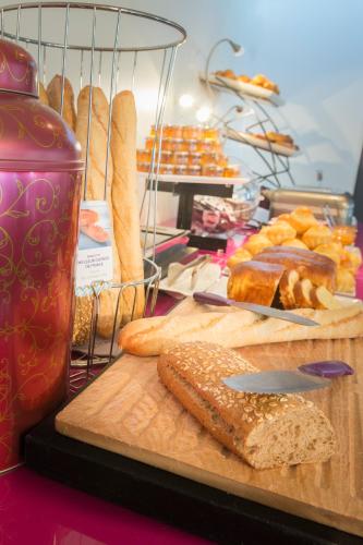 a table with a cutting board with bread and a knife at Mercure Paris Centre Tour Eiffel in Paris