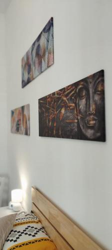 a bedroom with three pictures on the wall at Al Duca San Pietro in Carloforte