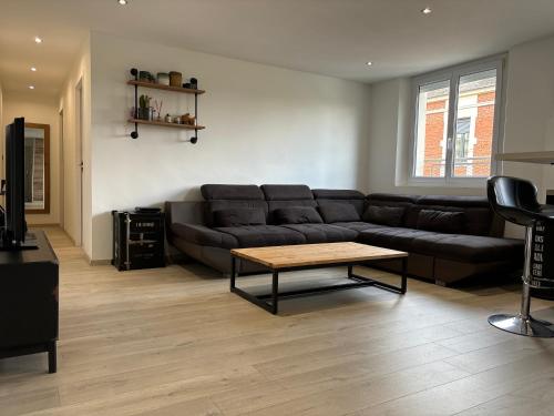 a living room with a couch and a coffee table at Appartement de Adrien Garage privé in Charleville-Mézières