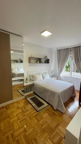 a bedroom with a bed and a large window at Apto Charmoso Próximo à Catedral in Santa Cruz do Sul