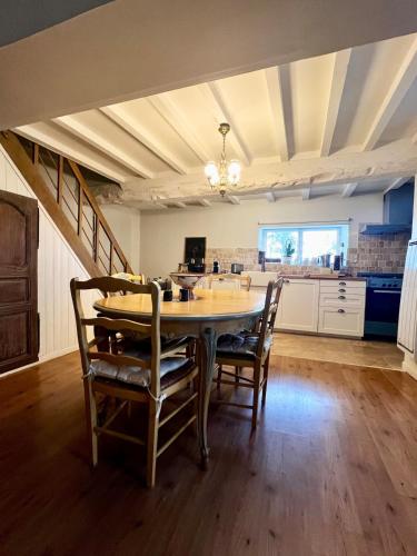 une cuisine et une salle à manger avec une table et des chaises dans l'établissement Cottage du Long Vey, à La Folie