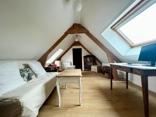 Cette chambre mansardée comprend un lit et un bureau. dans l'établissement Cottage du Long Vey, à La Folie