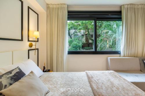 a bedroom with a bed and a large window at Studio de luxo e Sofisticado no Moinhos LBO203 in Auxiliadora