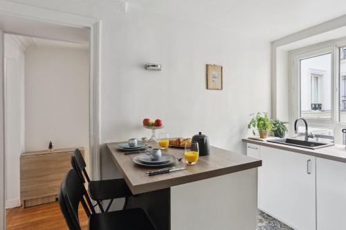 une cuisine avec une table et deux verres de jus d'orange dans l'établissement BnBNova - 2BR - Le Marais & Les Halles, à Paris