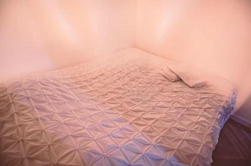 - un petit lit dans un coin de chambre dans l'établissement GEORGIE - Appartement atypique, à Reims