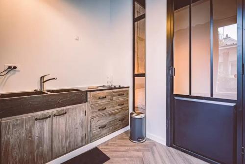 une cuisine avec des armoires en bois et un évier dans l'établissement GEORGIE - Appartement atypique, à Reims