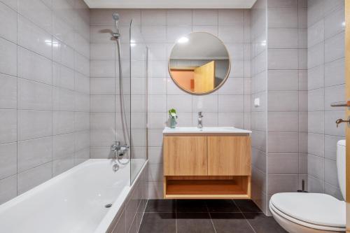 ein Badezimmer mit Waschbecken, Toilette und Spiegel in der Unterkunft Refúgio Girassol in Caniço