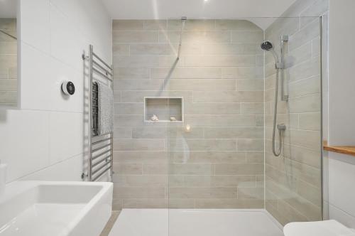 a bathroom with a shower with a tub and a sink at Stunning 3 Bed Barn close to Bigbury on Sea in Bigbury on Sea