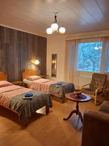 a hotel room with two beds and a table at Tuulanmajoitus in Mänttä