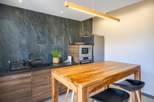 a kitchen with a wooden table and a refrigerator at Au temps des pêcheurs - Terre Sainte - Piscine chauffée in Saint-Pierre