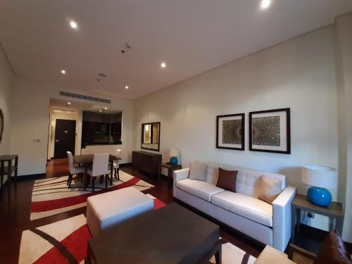 a living room with a white couch and a table at Luxe Getaways Royal Amwaj Palm Jumeirah Resort Apartment Holiday Home in Dubai
