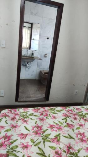 a mirror reflecting a bathroom with a bed and a sink at Hostel Eldorado Contagem in Contagem