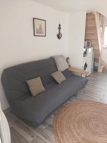 a blue couch in a living room at Petite maison bretonne 2 personnes accès piscine in Erquy
