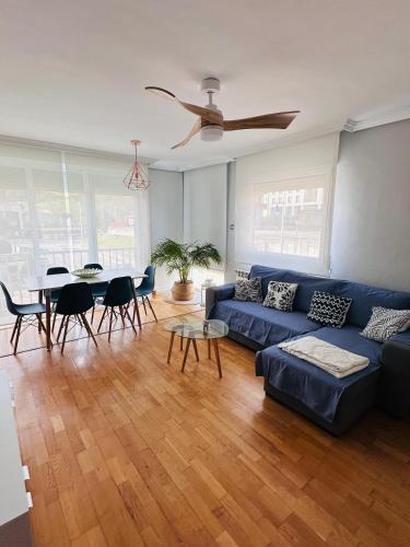 a living room with a blue couch and a table at Apartamento Costa del Sol Suances in Suances