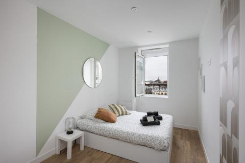 een witte kamer met een bed en een raam bij T3 Le Foudroyant in Brest