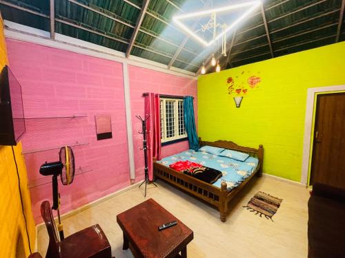 Zimmer mit einem Bett und einer rosa und grünen Wand in der Unterkunft LAKSHMI NIKUNj Estate Stay in Madikeri