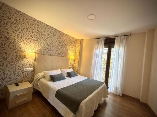 a bedroom with a large bed and a window at Hotel Molina Real in Molinaseca