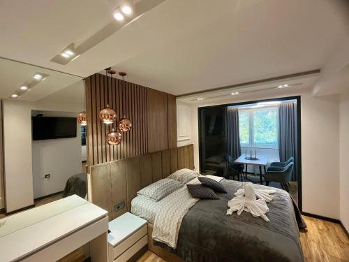 a bedroom with a large bed and a desk at Апартамент Мегилукс 2 in Blagoevgrad