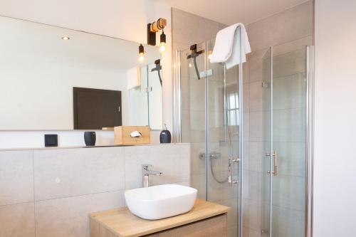 a bathroom with a sink and a shower at Chalet Bergzeit Family Wellness Suite in Braunlage