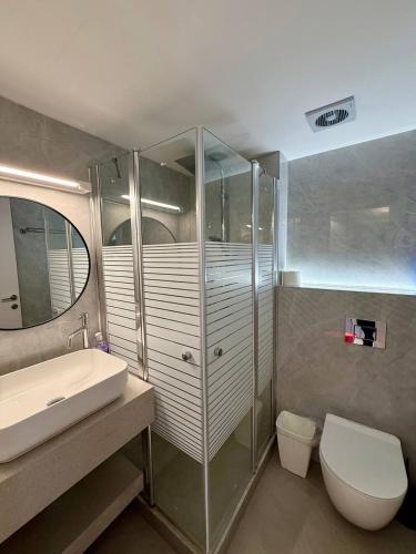 a bathroom with a sink and a toilet and a shower at Sea Breeze Studios in Netanya