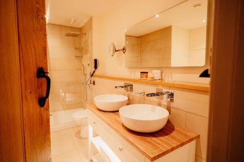 a bathroom with two white sinks on a counter at The Fleece at Ruleholme in Carlisle