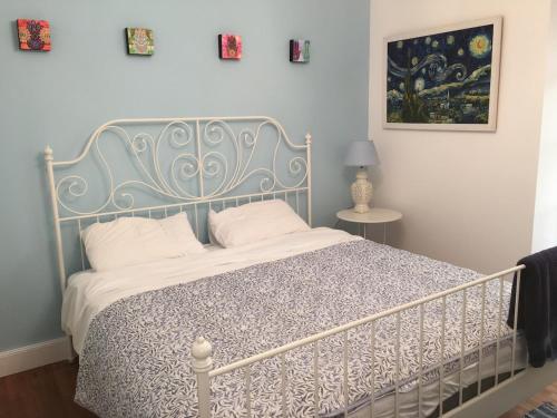 une chambre avec un lit avec un couvre-lit bleu et blanc dans l'établissement Ash Fountain Gardens, à Sarlat-la-Canéda