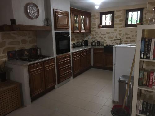 une cuisine avec des armoires en bois et un réfrigérateur blanc dans l'établissement Ash Fountain Gardens, à Sarlat-la-Canéda