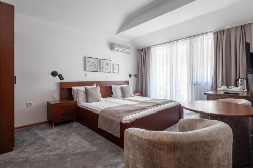 a bedroom with a bed and a table and a chair at Villa Dea in Ohrid