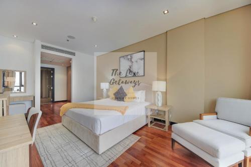a bedroom with a king sized bed and a couch at Luxe Getaways Royal Amwaj Palm Jumeirah Resort Apartment Holiday Home in Dubai