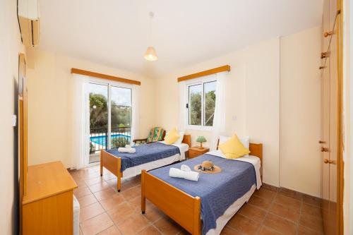a bedroom with two beds and a pool at Villa Katerina in Neo Chorio