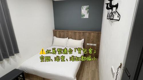 a small room with a bed with writing on it at Benz 賓士溫泉旅館 in Jiaoxi