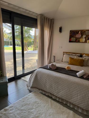 a bedroom with a large bed and a large window at Quinta Das Palmeiras in Valpedre