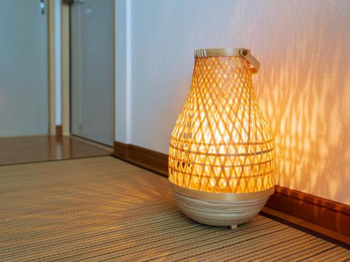 a vase sitting on the floor next to a wall at marugame stop1F in Marugame