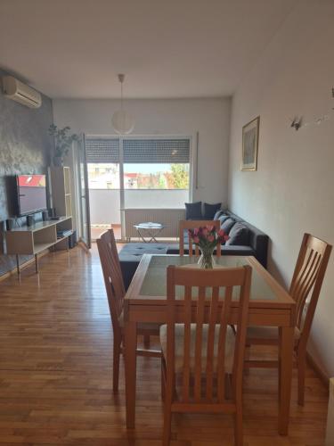 a dining room and living room with a table and chairs at Moni in Osijek